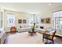 Bright living room with hardwood floors, neutral furniture, and natural light from multiple windows at 8951 E 59Th Pl, Denver, CO 80238