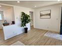 Bright living room features wood flooring, an artistic accent wall, and a modern open concept at 7956 Joan Dr, Denver, CO 80221