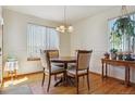Bright dining room with hardwood floors, large windows, and a stylish chandelier at 3787 Bucknell Dr, Highlands Ranch, CO 80129