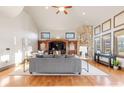 Bright living room with a stone fireplace, custom built-ins, and hardwood floors at 5810 Amber Ridge Dr, Castle Pines, CO 80108