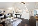 Bright and airy living room showcasing vaulted ceilings, modern decor, and seamless flow to the kitchen and dining area at 555 W Peakview Ave, Littleton, CO 80120