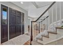 Inviting entryway with a dark front door, wooden floors, and staircase with white spindles at 7114 Mountain Brush Cir, Highlands Ranch, CO 80130