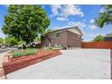Brick home showcasing a well-maintained exterior and a spacious driveway and manicured lawn at 11855 Humboldt Dr, Northglenn, CO 80233