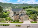 Two-story home with lush landscaping and a view of the mountains at 1788 Holmby Ct, Castle Rock, CO 80104
