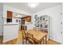 Bright dining area with hardwood floors, a light wood dining table, and built-in shelving for storage at 8335 Fairmount Dr # 9-201, Denver, CO 80247