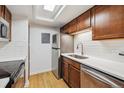 Updated kitchen features stainless steel appliances, white subway tile, and light hardwood floors at 8335 Fairmount Dr # 9-201, Denver, CO 80247
