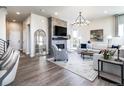 Bright living room features a fireplace, large mirror, modern chandelier and hardwood floors at 6235 Stable View St, Castle Pines, CO 80108