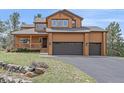 Inviting exterior showcasing a covered porch and two-car garage at 3173 Gold Yarrow Ln, Evergreen, CO 80439
