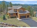 Charming two-story home featuring a front porch and an attached two-car garage at 3173 Gold Yarrow Ln, Evergreen, CO 80439