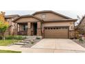 Attractive home featuring a covered porch, stone accents, a two-car garage, and a concrete driveway at 25120 E Maple Pl, Aurora, CO 80018