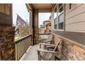 Cozy front porch featuring chairs, stone accents, and a charming view of the neighborhood at 25120 E Maple Pl, Aurora, CO 80018