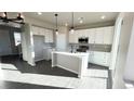 Bright kitchen featuring white cabinets, stainless steel appliances, stylish pendant lighting, and an island at 16805 Mckay Dr, Mead, CO 80542