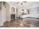 Open concept living area with a cozy fireplace, hardwood floors, and a view of the kitchen at 14400 Albrook Dr # 43, Denver, CO 80239