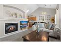 Comfortable living room showcasing a fireplace, TV, cozy seating, and open layout to the kitchen at 22610 E Ontario Dr # 204, Aurora, CO 80016