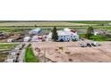 Property aerial showing multiple buildings, pens, and large parking area at 1614 N Manila Rd, Bennett, CO 80102