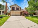 Charming two-story home with a well-maintained lawn and a spacious driveway with a two car garage at 2590 W Long Cir, Littleton, CO 80120