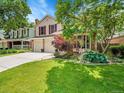 Charming two-story home with manicured lawn, mature trees, and a convenient two car garage at 2590 W Long Cir, Littleton, CO 80120