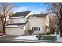 Beige two-story home with attached garage and snow-covered yard at 4530 S Verbena St # 309, Denver, CO 80237