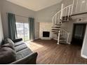 Living room with fireplace, spiral staircase, and sliding door to balcony at 15350 E Arizona Ave # 308, Aurora, CO 80017