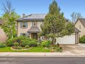 Attractive two-story brick home featuring a manicured lawn, mature trees, and a driveway leading to an attached garage at 12610 E Villanova Dr, Aurora, CO 80014