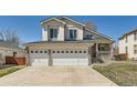 Attractive two-story home with a three-car garage, stone accents, well-manicured lawn, and inviting front porch at 12771 Clermont St, Thornton, CO 80241