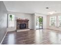 Open living room boasts hardwood floors, stone fireplace, and balcony access at 10950 W Florida Ave # 314, Lakewood, CO 80232