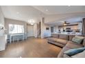 Open-concept living room with wood floors, a large sectional, and an adjacent kitchen provides ample space at 5431 E 129Th Ave, Thornton, CO 80241