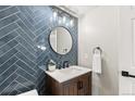 Stylish powder room with blue herringbone tile, round mirror, and a modern vanity at 7476 E Arkansas Ave # 35-01, Denver, CO 80231