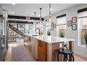 Modern kitchen featuring a large center island, stainless steel appliances, and a view of the staircase at 3636 Lipan St, Denver, CO 80211