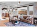 Inviting living room featuring hardwood floors, a leather sofa, and a view into the adjacent modern kitchen at 3636 Lipan St, Denver, CO 80211