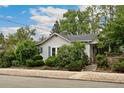 Quaint home with a mature front yard and attractive curb appeal and featuring blue window shutters at 1900 S Gilpin St, Denver, CO 80210