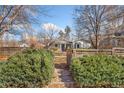 Landscaped front yard with walkway leading to a charming home, framed by greenery and a wooden fence at 1900 S Gilpin St, Denver, CO 80210