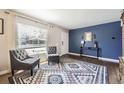 Inviting living room with elegant decor, featuring a striking blue accent wall and stylish seating arrangement at 1475 Lucille Ct, Northglenn, CO 80233