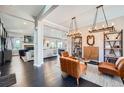 Open-concept living room with dark hardwood floors, stylish furnishings, and modern light fixtures at 5923 S Jamestown Ct, Aurora, CO 80016