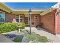 Inviting brick home entrance with colorful flowers and a seating area, creating a warm welcome at 2700 W Riverwalk Cir # C, Littleton, CO 80123