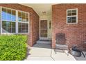 Charming front entrance with brick facade, decorative security door, and seating at 2700 W Riverwalk Cir # C, Littleton, CO 80123