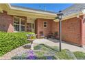 Inviting brick home entrance with colorful flowers and a seating area, creating a warm welcome at 2700 W Riverwalk Cir # C, Littleton, CO 80123
