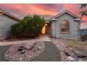 Charming front entrance with a decorative walkway, mature landscaping, and arched window at 265 Ox Yoke Way, Monument, CO 80132