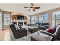 Comfortable living room showcasing a cozy fireplace, large windows, and plush leather furniture at 11020 E 150Th Pl, Brighton, CO 80602