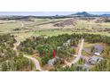 Beautiful aerial view of property nestled amongst the trees with mountain views and treed landscaping at 4185 Cheyenne Dr, Larkspur, CO 80118