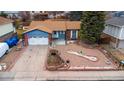 Aerial view of a well-maintained blue single-story home with a two-car garage and lovely front yard at 11397 Kendall St, Westminster, CO 80020
