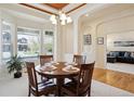 A dining room with a wooden table, four chairs, and a large window that provides a view of the neighborhood at 8068 Dressage Rd, Littleton, CO 80125