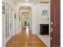 Bright hallway featuring hardwood floors, arched doorways, and neutral paint scheme at 8068 Dressage Rd, Littleton, CO 80125