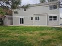 Spacious backyard featuring a lush lawn, shed, and the exterior of the home with sliding glass doors and windows at 11427 Brownstone Dr, Parker, CO 80138