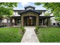 Inviting stone-clad home with a grand entrance, covered porch, and well-manicured lawn at 1351 S Milwaukee St, Denver, CO 80210