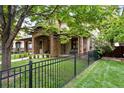 Attractive home with stone accents, a covered porch, and a black metal fence surrounding the property at 1351 S Milwaukee St, Denver, CO 80210