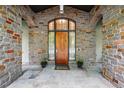 A stone front entrance features a wood door with a large arched window and welcome mat at 1351 S Milwaukee St, Denver, CO 80210