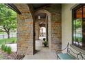 A stone-paved porch with arches showcasing bench seating with manicured shrubs at 1351 S Milwaukee St, Denver, CO 80210