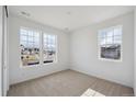 Bright bedroom featuring carpeted floors, two large windows, and neutral walls at 1281 Rock Cliff Ave, Erie, CO 80516