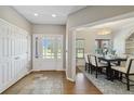 Inviting entryway leading to dining area, featuring tile flooring, coat closet, and sunlit view at 1550 Ajax St, Strasburg, CO 80136